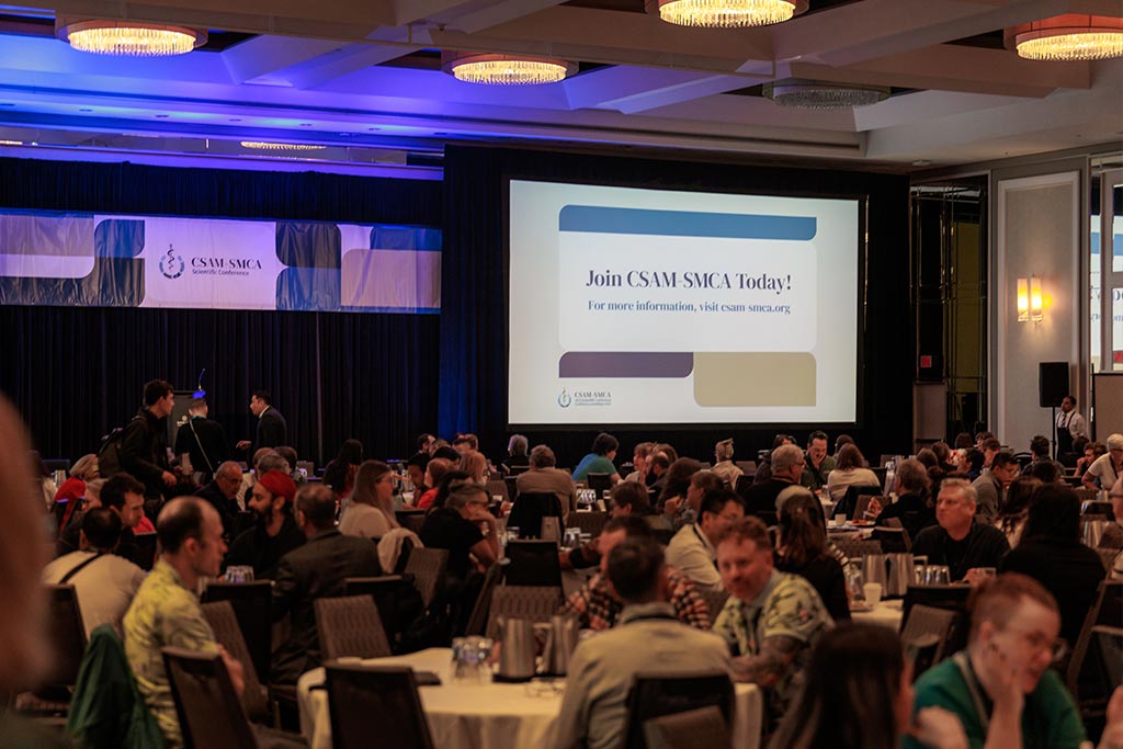 Conference Room full of people with slide showing Join CSAM Today