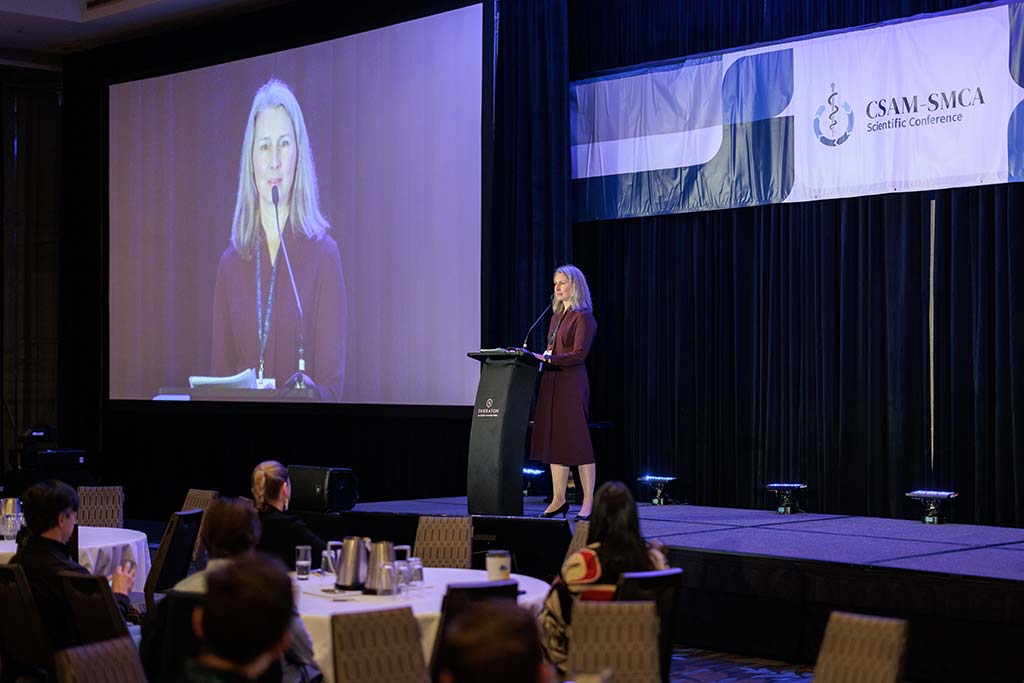Woman presenting on stage at CSAM conference