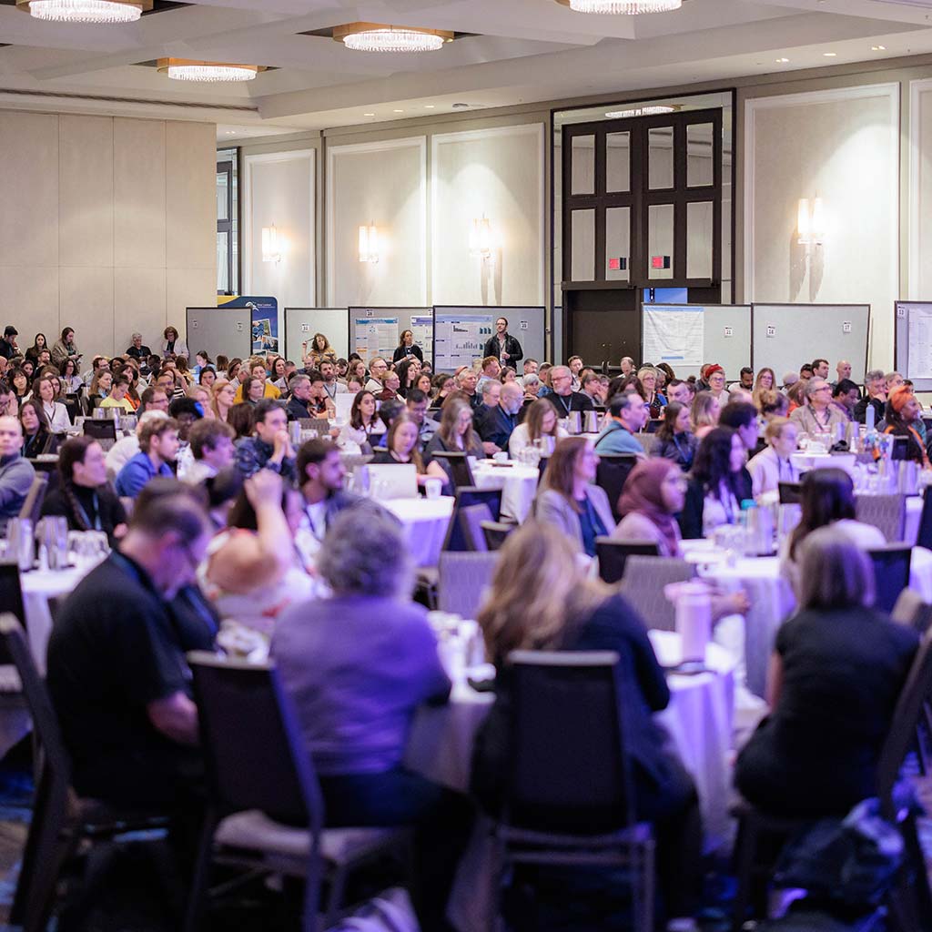 Conference Room full of attendees sitting at round tables